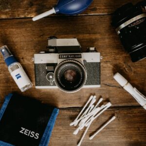 black and silver dslr camera beside white and black disposable lighter