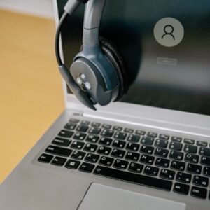 Close-up of a laptop with a headset, symbolizing online communication and remote work.