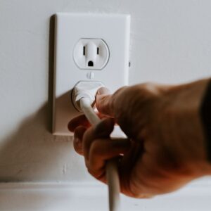 person holding white electric plug
