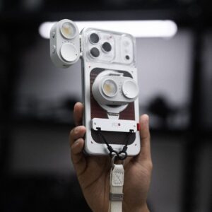 Hand holds white phone case with attached lights.