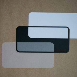 a couple of white and black coasters on a brown surface