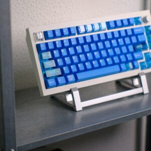 A mechanical keyboard with blue keycaps on a metal stand.