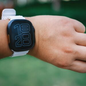 A person is wearing a white smartwatch.