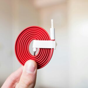 person holding white and red cable
